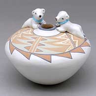Click for a larger view A polychrome seed pot decorated with a geometric design on top and a pair of polar bear appliques with heishi beads
by Stella Teller of Isleta