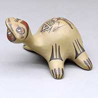 A polychrome turtle figure decorated with a painted yeibichai and geometric design
 by Margaret and Luther Gutierrez of Santa Clara