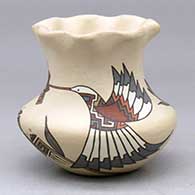 A small polychrome jar with a recurved neck and pie crust rim, decorated with a hummingbird, flower, butterfly and geometric design
 by Lois Gutierrez of Santa Clara