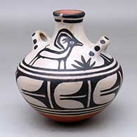 A polychrome jar with handles and decorated with a black on white mountain goat, plant and geometric design
 by Robert Tenorio of Santo Domingo