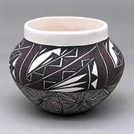 A polychrome jar decorated with a snowflake fineline design below the shoulder and a four-panel geometric design above
 by LaDonna Victorino of Acoma