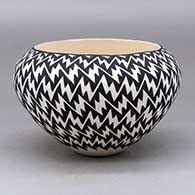 A black on white bowl decorated on the outside with a lightning bolt geometric design
 by Jennifer Estevan of Acoma