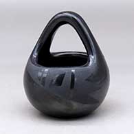 A black on black basket decorated with a two-panel geometric design
 by Flora Naranjo of Santa Clara