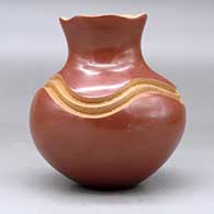 A red jar with a pie crust rim and decorated with a carved geometric design painted with micaceous clay, click or tap to see a larger version