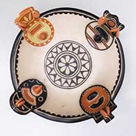 A polychrome bowl with four mudhead masks, earrings and a geometric design inside and out
 by M. Janice Ortiz of Cochiti