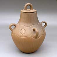A brown and golden micaceous lidded jar with four handles and a carved geometric design above the shoulder
 by Jody Naranjo of Santa Clara