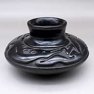 A black, low-shouldered jar carved with a double avanyu design above the shoulder
 by Richard Ebelacker of Santa Clara