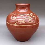 A red jar with a recurved neck and carved with an avanyu and geometric design above the shoulder
 by Richard Ebelacker of Santa Clara