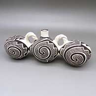 Distinctive black-on-white triple-lobed canteen with braided handles and a fine line, spiral, and geometric design
 by Juana Leno of Acoma