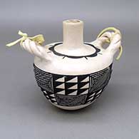 Black-on-white canteen with braided handles, a fine line and geometric design, and a leather strap
 by Marcella Augustine of Acoma