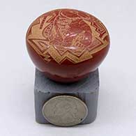 A miniature red seed pot decorated with a sgraffito rabbit and geometric design, click or tap to see a larger version