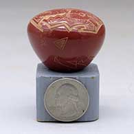 A miniature red seed pot decorated with a sgraffito rabbit and geometric design, click or tap to see a larger version