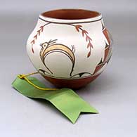 A polychrome jar decorated with a four panel deer, branch, leaf and geometric design, Honorable Mention ribbon from 1981 Deer Dancer Pottery Show
 by Gloria Gachupin of Zia
