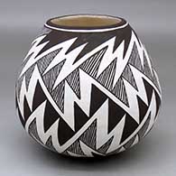 A black-on-white jar decorated with a fine line and lightning bolt geometric design
 by Carmel Lewis of Acoma