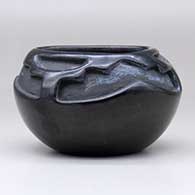 A black bowl with a triangular opening and carved with a three-panel geometric design above the shoulder, click or tap to see a larger version