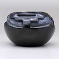 A black bowl with a triangular opening and carved with a three-panel geometric design above the shoulder, click or tap to see a larger version