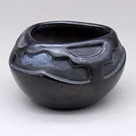 A black bowl with a triangular opening and carved with a three-panel geometric design above the shoulder
 by Frances Salazar of Santa Clara