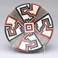 A small polychrome plate decorated with a four-panel geometric design
 by Cruz Renteria of Mata Ortiz and Casas Grandes
