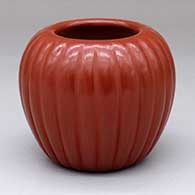 A red jar carved with a 24-rib melon design
 by Angela Baca of Santa Clara