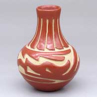 A small red water jar carved with an avanyu and ring of feathers design
 by Denise Chavarria of Santa Clara