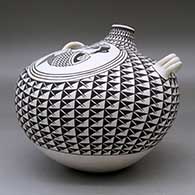 A large black on white canteen with handles and decorated with a crane and fish medallion surrounded by a spiral mesa geometric design, click or tap to see a larger version