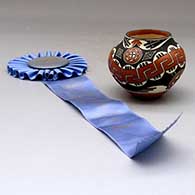 A small polychrome jar decorated with a replica Acoma design from between 1850 and 1900, First Place ribbon from 1989 Santa Fe Indian Market
 by Wanda Aragon of Acoma