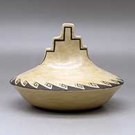 A black on brown jar with a kiva step cut rim ad decorated above the low shoulder with a corn stalk and geometric design, click or tap to see a larger version