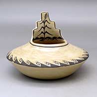 A black on brown jar with a kiva step cut rim ad decorated above the low shoulder with a corn stalk and geometric design
 by Juanita Fragua of Jemez