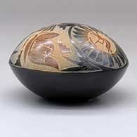 A black seed pot with sienna spots and a sgraffito medallion, kokopelli, yeibichai, butterfly and geometric design above the shoulder, click or tap to see a larger version