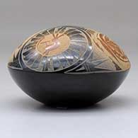 A black seed pot with sienna spots and a sgraffito medallion, kokopelli, yeibichai, butterfly and geometric design above the shoulder, click or tap to see a larger version