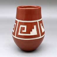 A red jar carved with a four-panel kiva step and spiral geometric design
 by Daryl Whitegeese of Santa Clara and Pojoaque