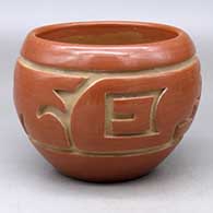 A red bowl carved around the body with a stylized avanyu and geometric design
 by LuAnn Tafoya of Santa Clara