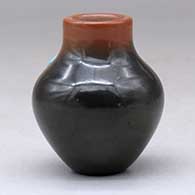 A miniature two-tone jar with an inlaid stone, click or tap to see a larger version