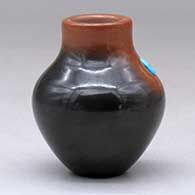 A miniature two-tone jar with an inlaid stone, click or tap to see a larger version