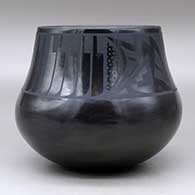 A black on black jar decorated with a band of feathers and geometric design above the shoulder, plus an inlaid stone, click or tap to see a larger version