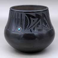 A black on black jar decorated with a band of feathers and geometric design above the shoulder, plus an inlaid stone
 by Cavan Gonzales of San Ildefonso