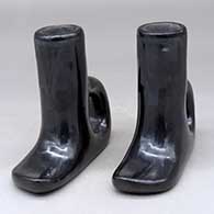 A pair of black on black candlestick holders with handles and decorated with a kiva step and geometric design
 by Rose Gonzales of San Ildefonso