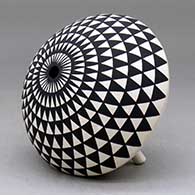 A black on white seed pot with legs and decorated with a geometric design above the shoulder, click or tap to see a larger version
