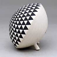 A black on white seed pot with legs and decorated with a geometric design above the shoulder, click or tap to see a larger version