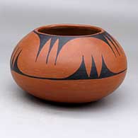 A black on red bowl decorated with a bat wing and geometric design
 by Tonita Roybal of San Ildefonso