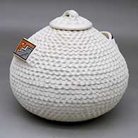 A corrugated lidded white jar with polychrome geometric designs on the handles
 by Stella Shutiva of Acoma