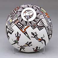 A polychrome seed pot decorated with a kokopelli, lizard and geometric design
 by Carolyn Concho of Acoma