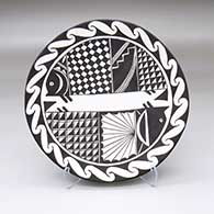 A black-on-white plate decorated with a Mimbres fish and geometric design
 by Patrick Chino of Acoma