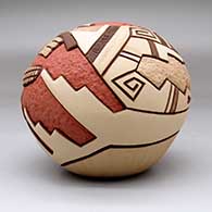 A carved and painted polychrome seed pot decorated with a pueblo dancer, corn stalk and geometric design, click or tap to see a larger version