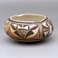 A polychrome tourist market bowl decorated with a four-panel geometric design around the body
 by Marie Koopee of Hopi