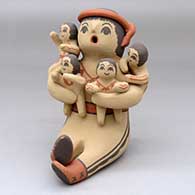 A sitting grandfather storyteller figure with four children
 by Linda Lucero Fragua of Jemez