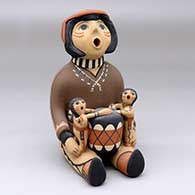 A sitting grandfather storyteller figure with a drum and two children
 by Leonard Tsosie of Jemez