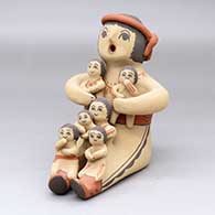 A sitting grandfather storyteller figure with six children on him
 by Linda Lucero Fragua of Jemez