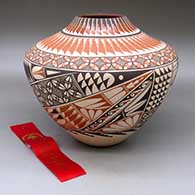 A high-shouldered jar decorated with a feather, seed, bird element, fine line and geometric design, Second Place ribbon Santa Fe Indian Market 1993
 by Geraldine Sandia of Jemez