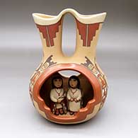 A polychrome wedding vase with cutouts, a geometric design, and the married couple standing inside
 by Marie G Romero of Jemez